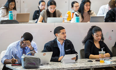 Dell Med students sit in an auditorium for a lecture.