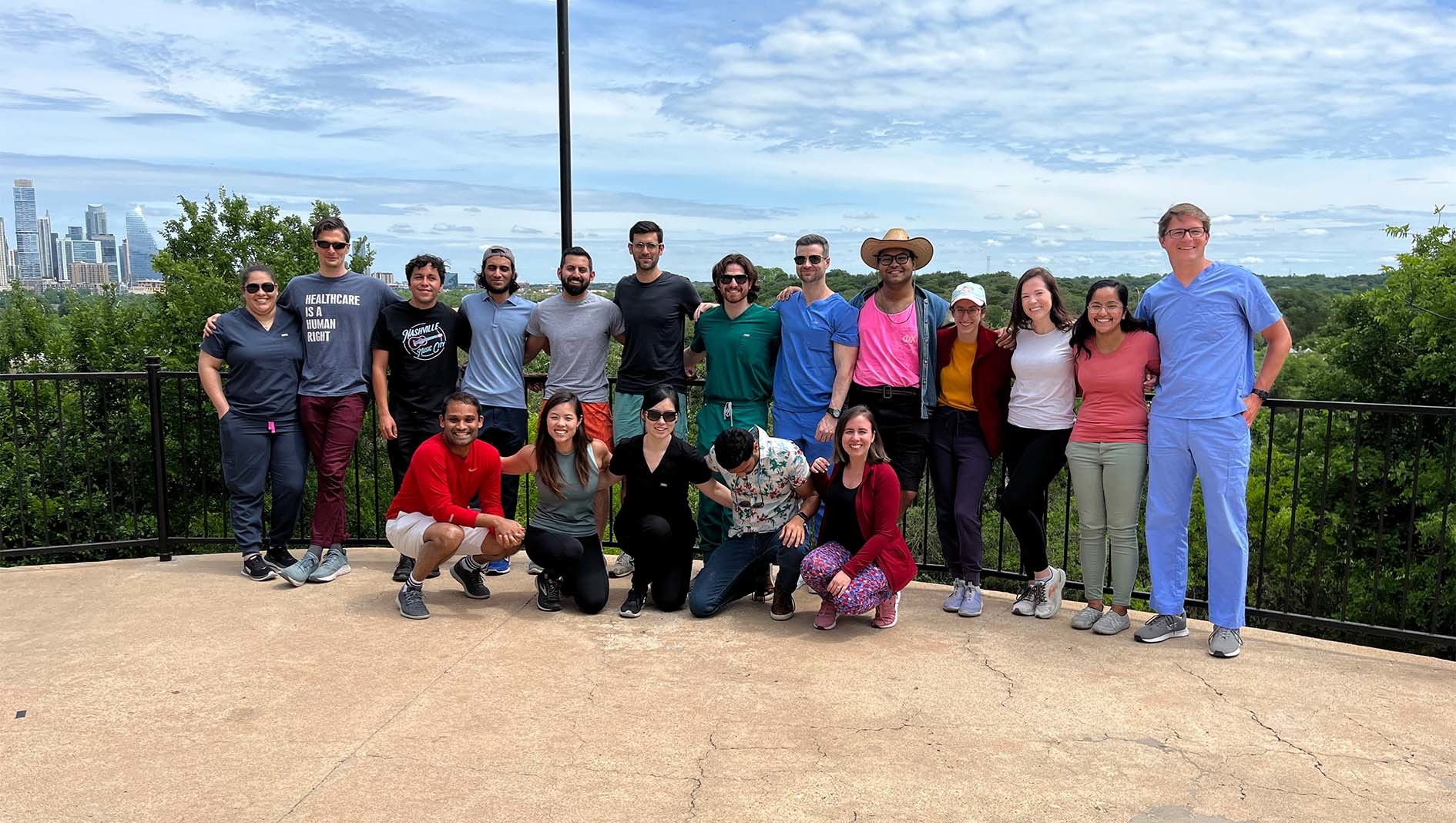 A large group of internal medicine residents pose together by an outdoor path.