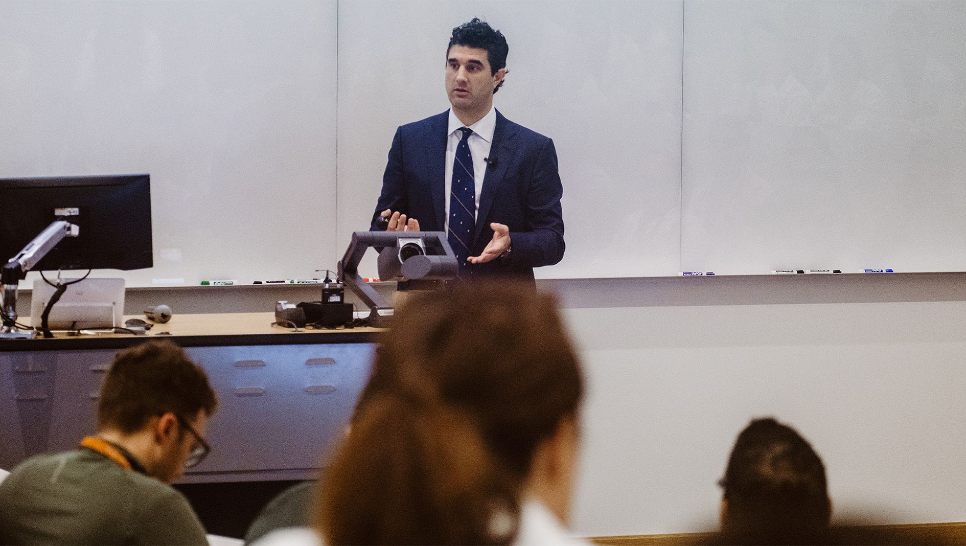 George Arnaoutakis delivers a grand rounds lecture inside a Dell Medical School auditorium.