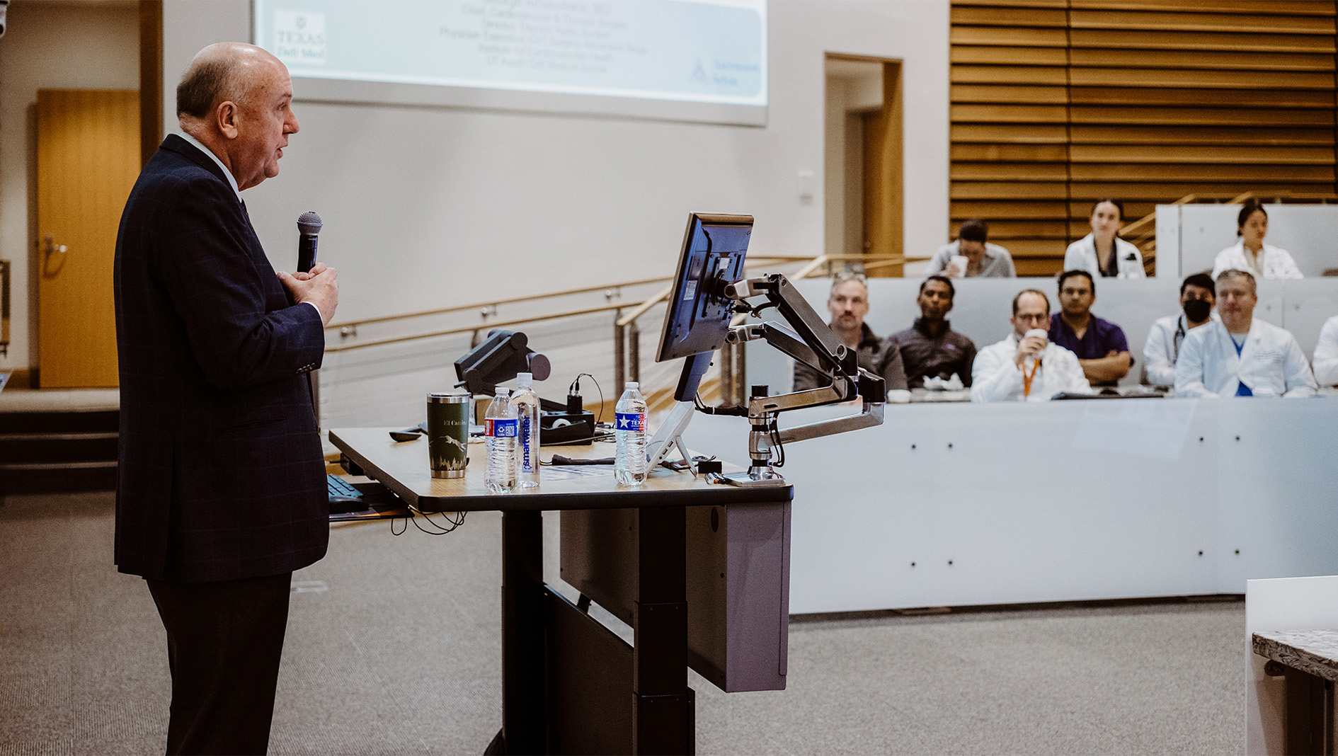 Charles Fraser delivers a grand rounds lecture inside a Dell Medical School auditorium.