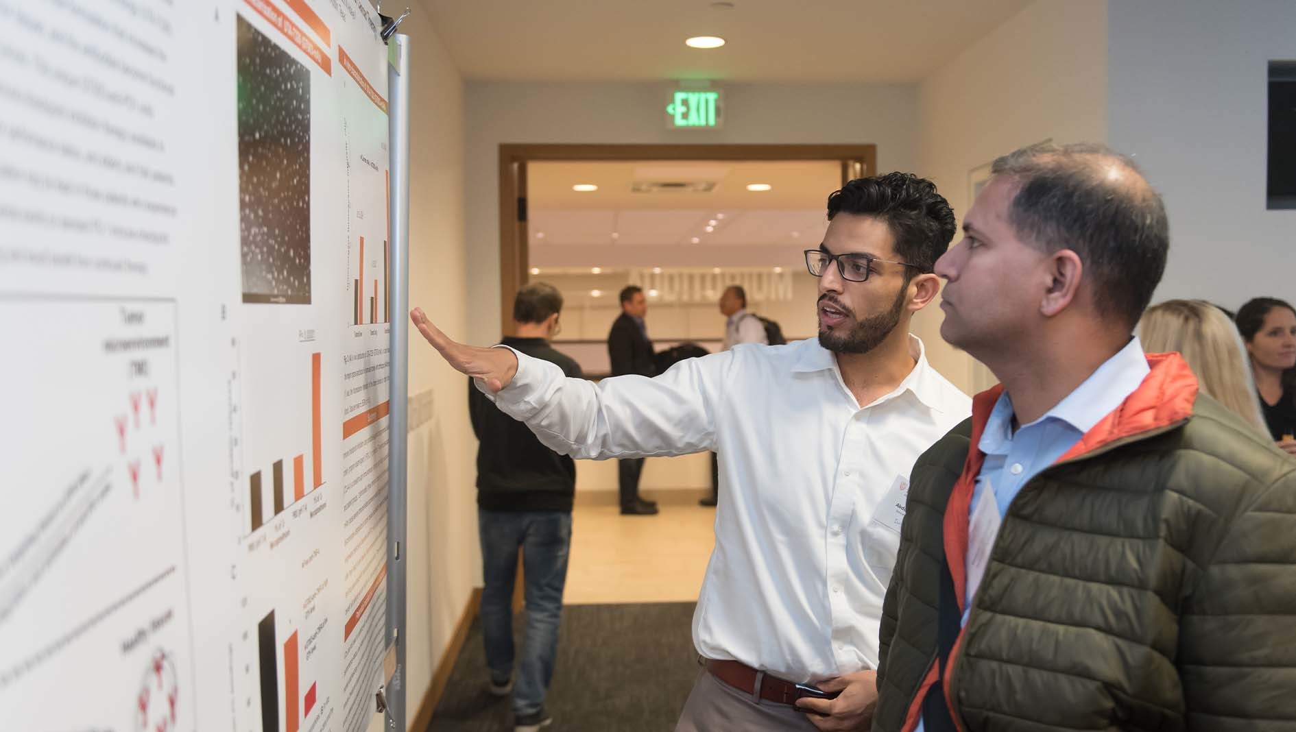 Two individuals discussing a project poster.