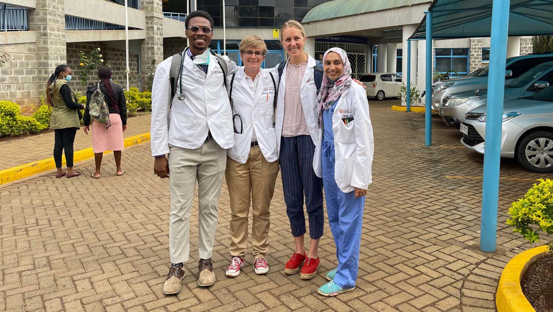 Dell Med students and a member of the Division of Global Health pose together for a small group photo.