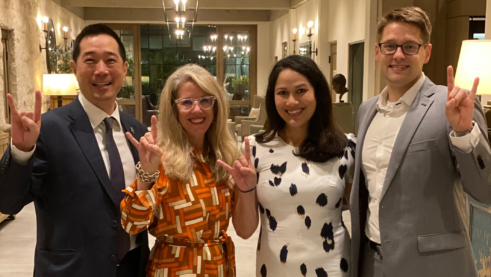 Four members of the Ophthalmology Residency posing in a group photo with the Hook 'em horns hand sign.