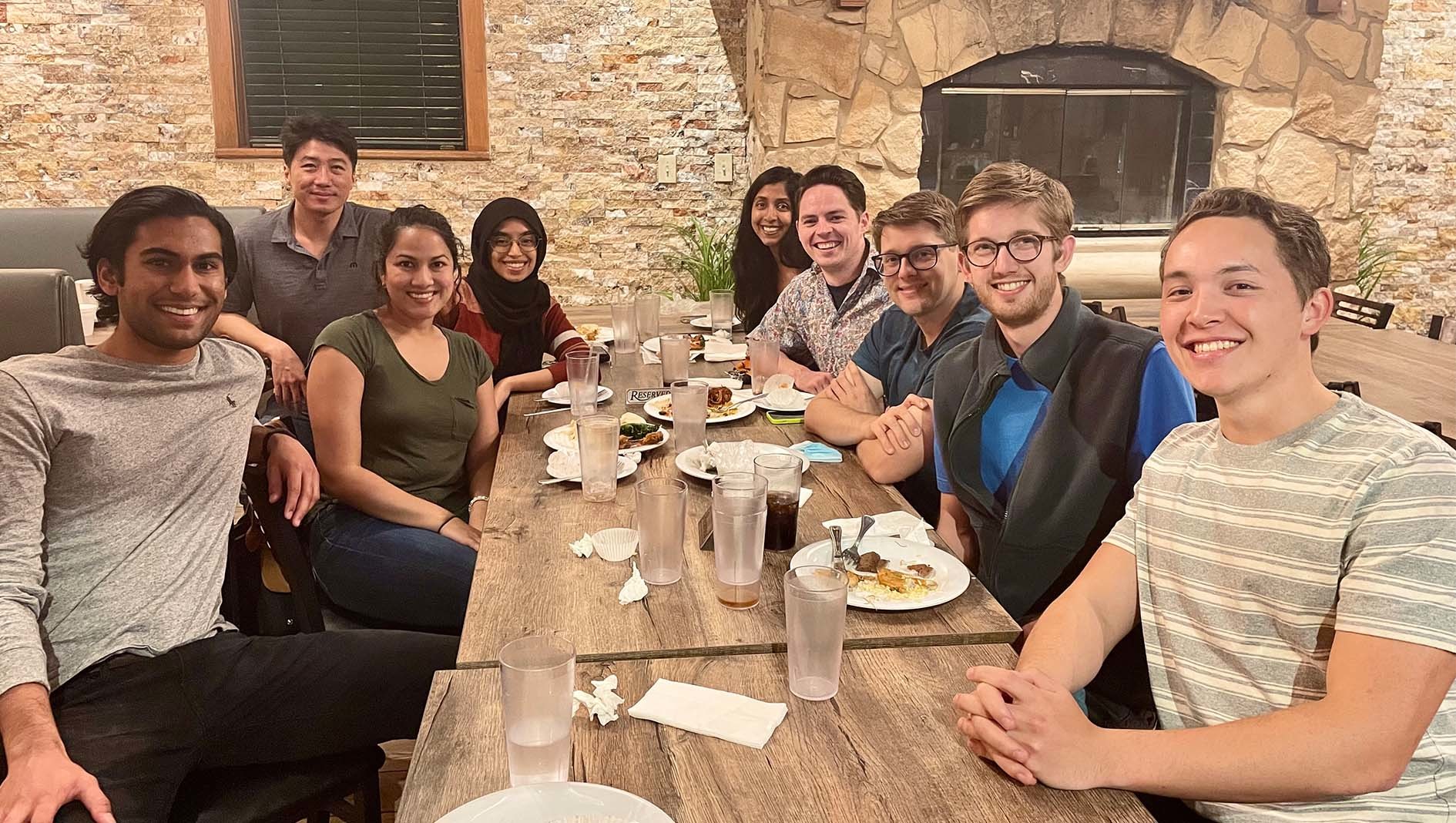 Members of Dell Med's ophthalmology student interest group pose together at a restaurant table.