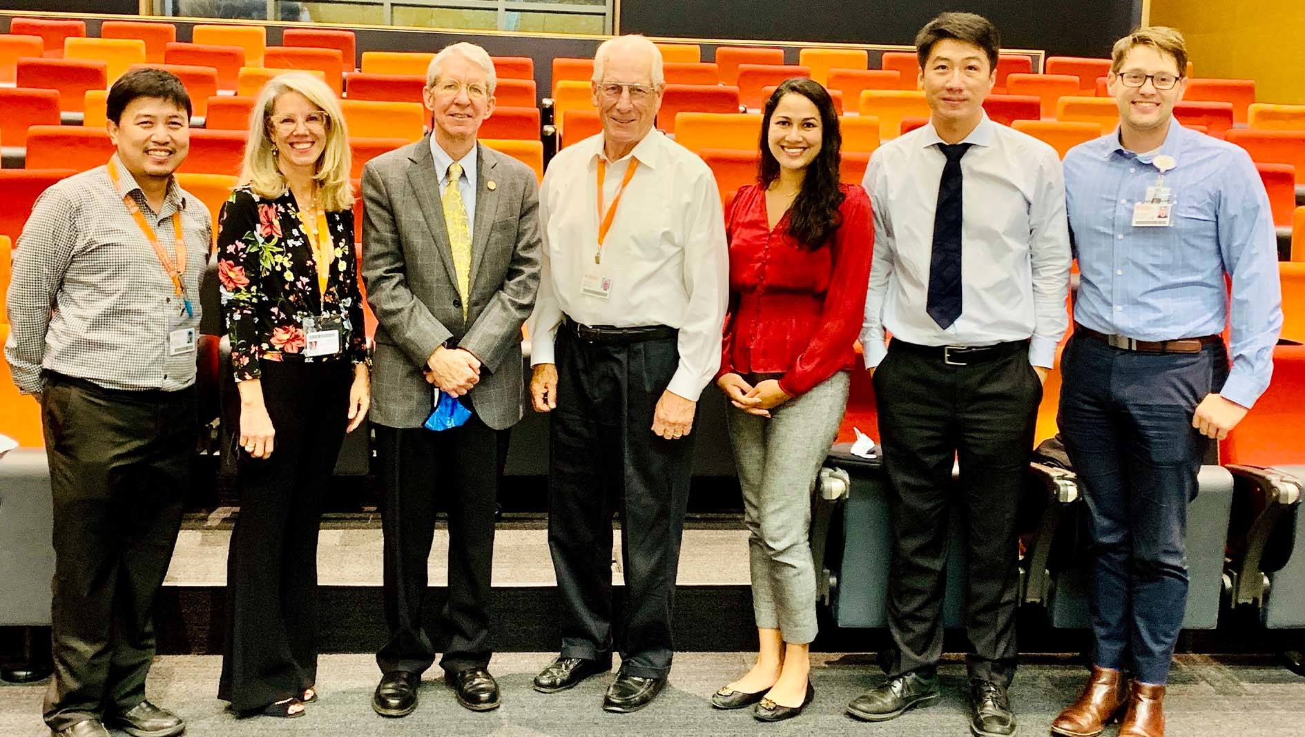 Faculty members from Dell Medical School's Ophthalmology Residency pose together in an auditorium.