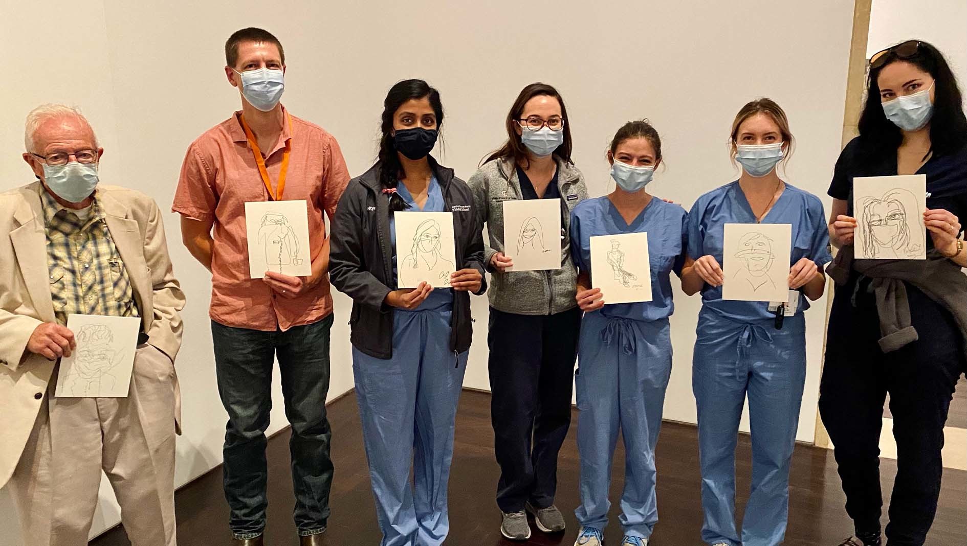 Seven members of Dell Med's Transitional Residency each holding sketched portraits.