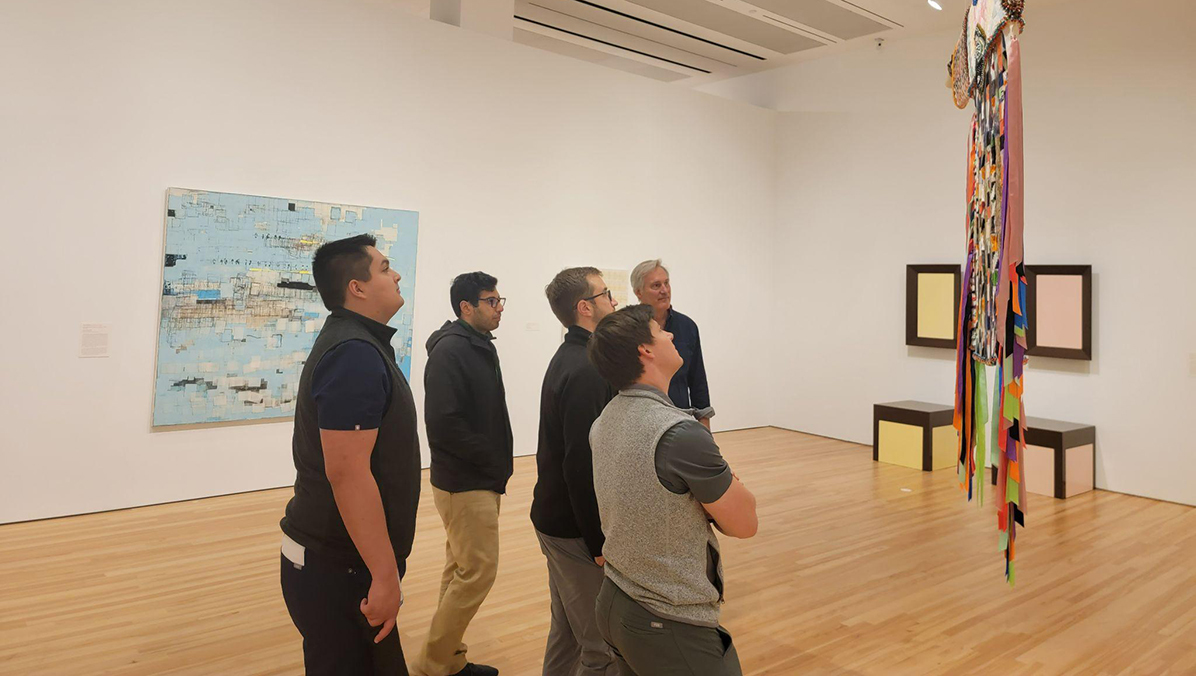 Group photo of the transitional year residents looking at artwork