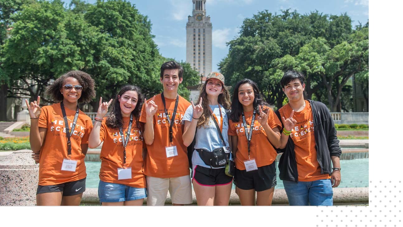 Summer camp participants pose for a photo in front of the UT Tower.