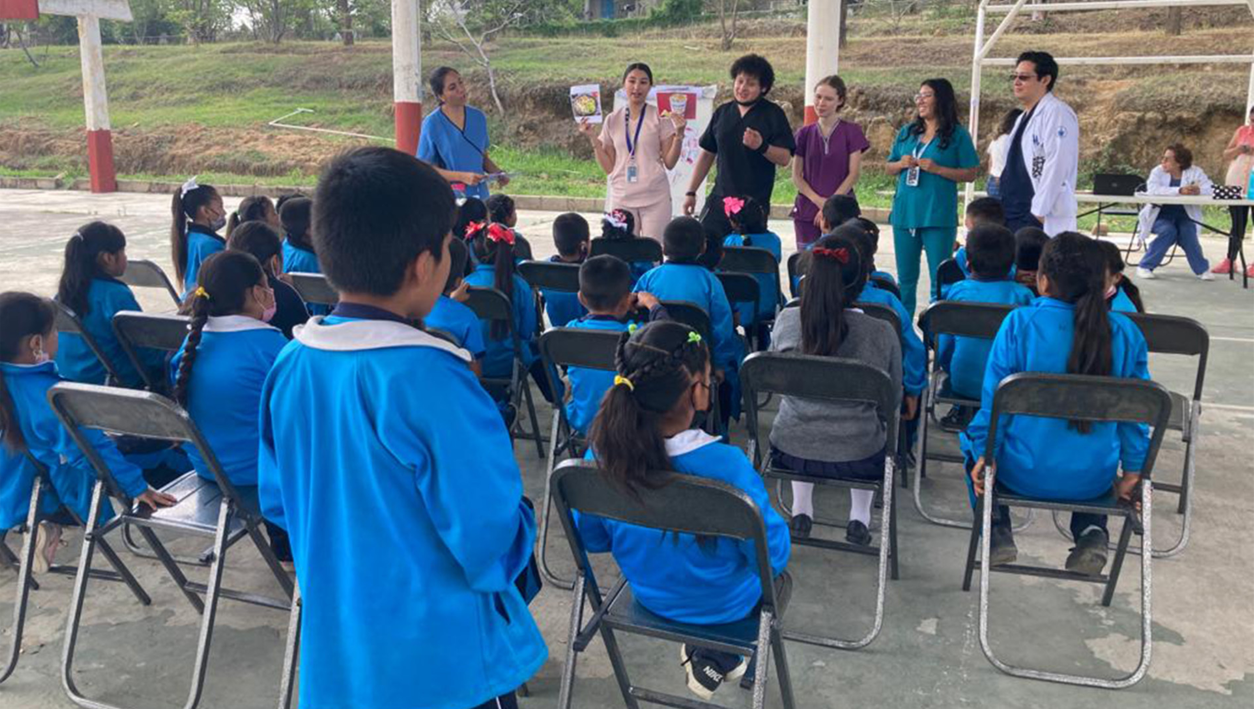 Pasantes and other clinicians from BUAP’s medical school deliver a health presentation to children at a rural primary school in San Francisco Xochiteopan, Puebla.