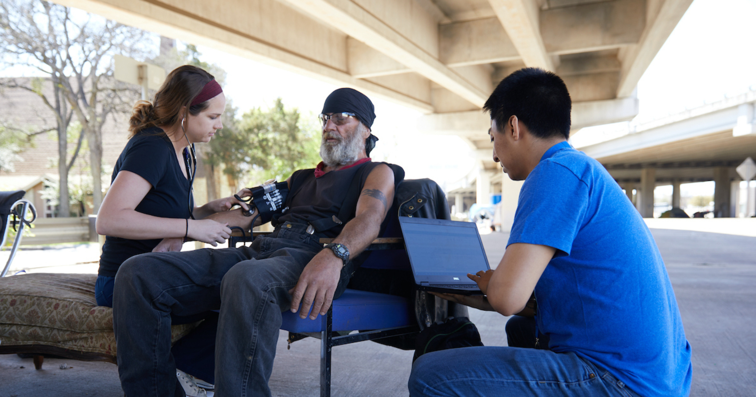 Physicians check the vitals of an individual experiencing homelessness.