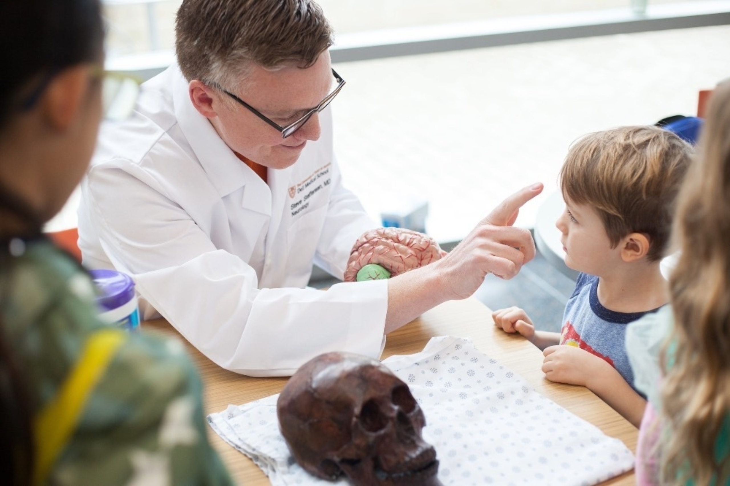 A Dell Med educator engages with a young boy during an Explore UT event.