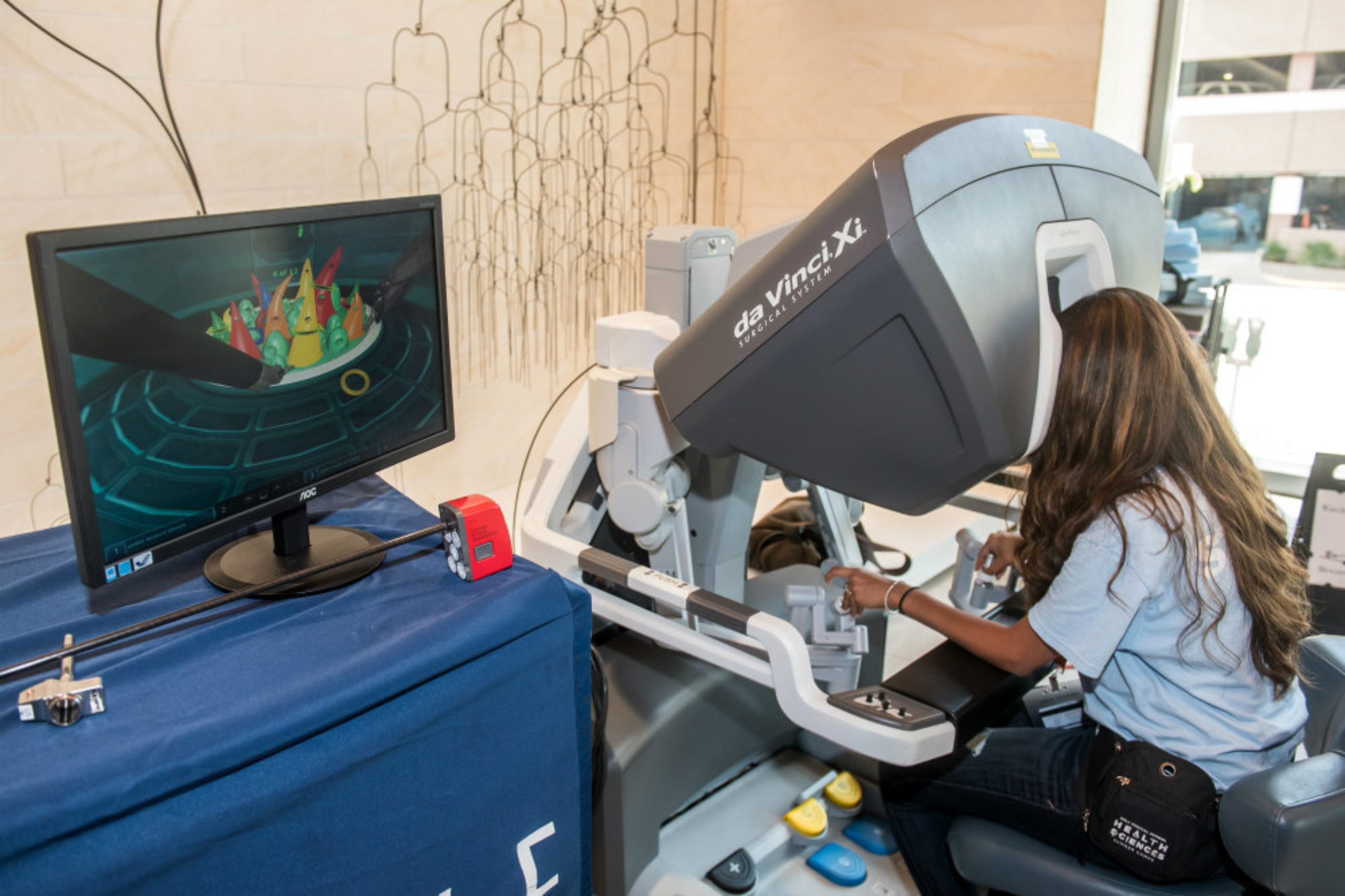 A summer camp participant uses the Da Vinci robot surgical simulation tool.