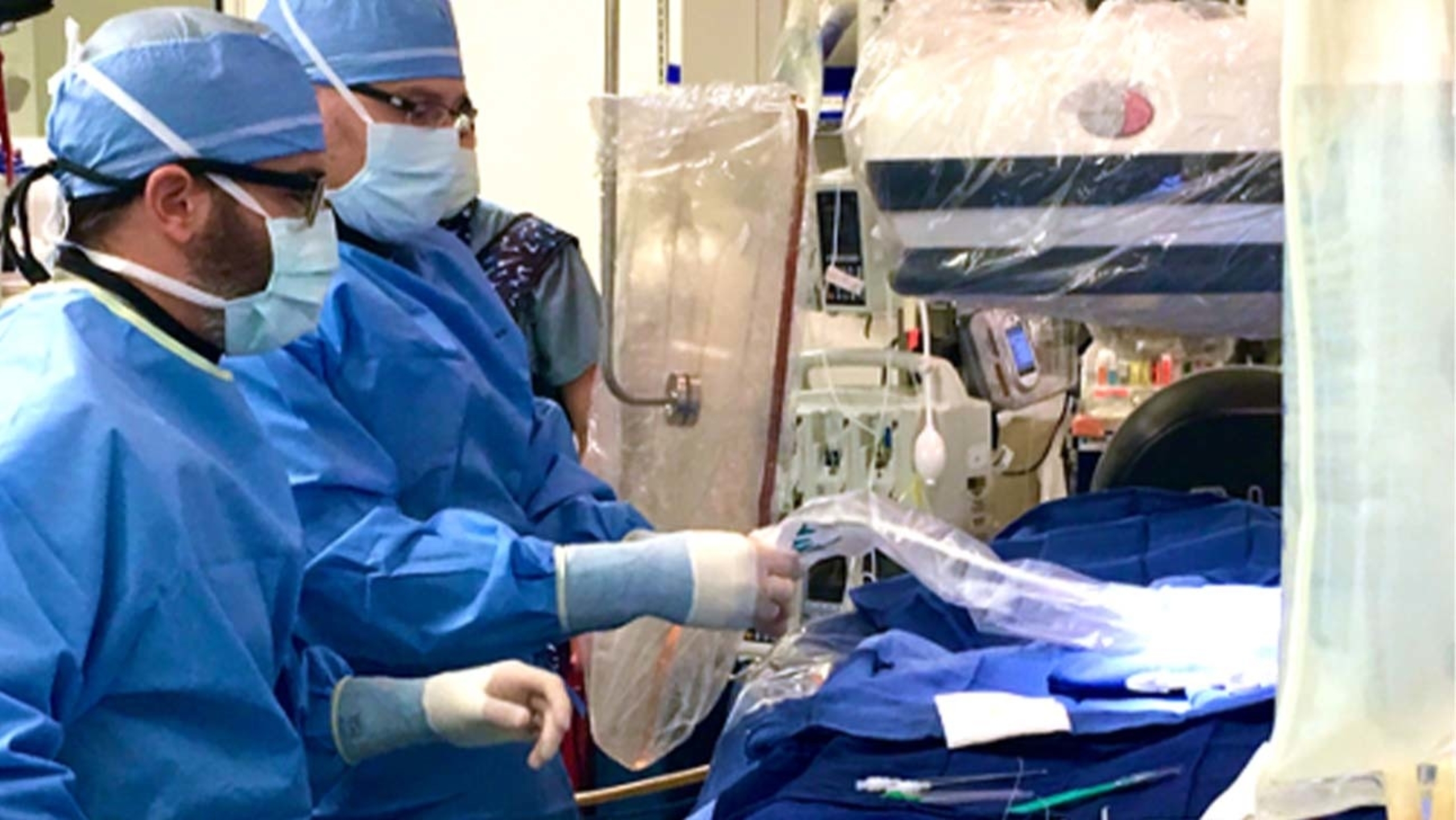 Two surgeons in scrubs performing a procedure in the operating room.