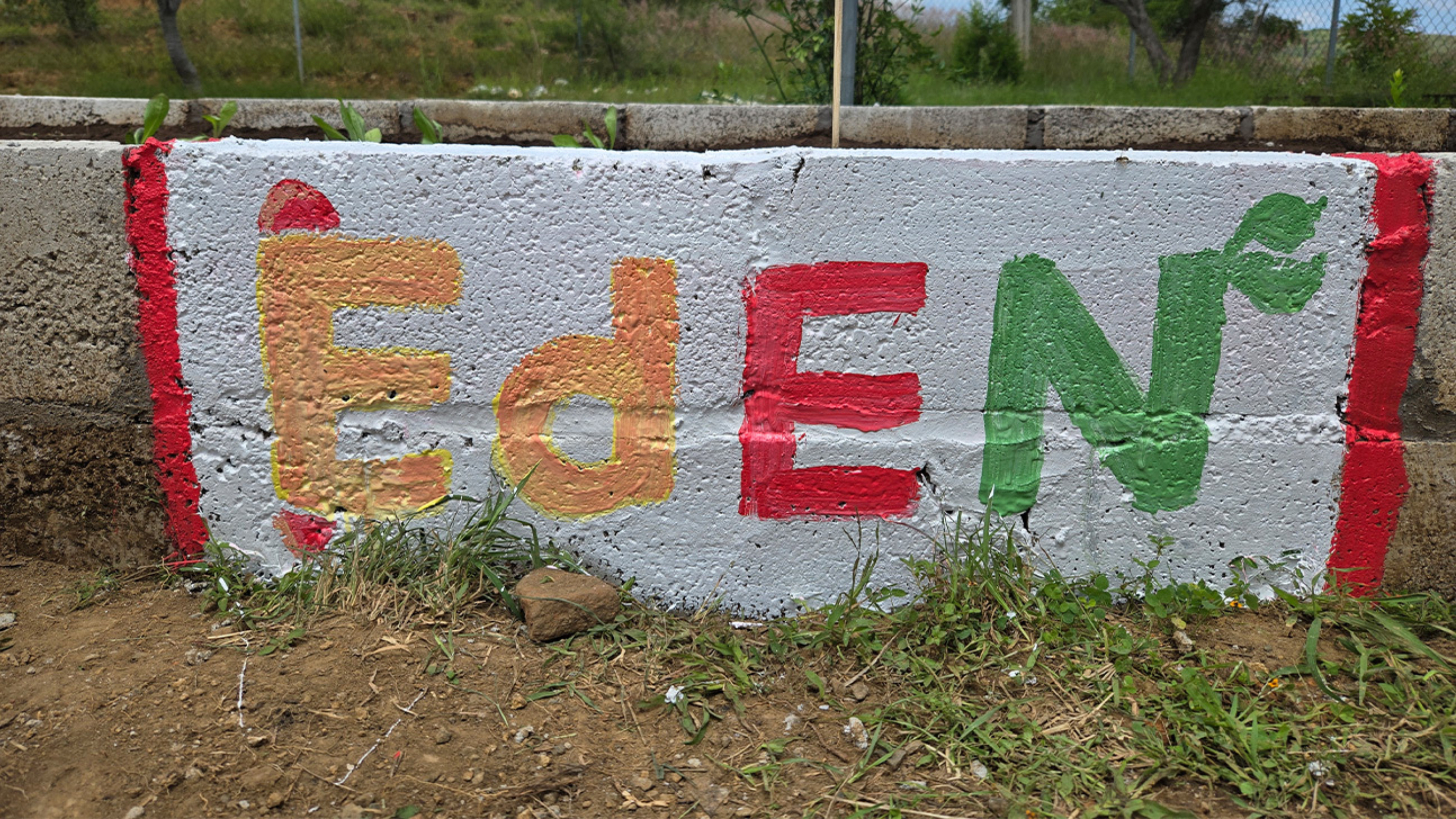 "Eden" (representing the Eden Lab) painted on the stone border of a garden.