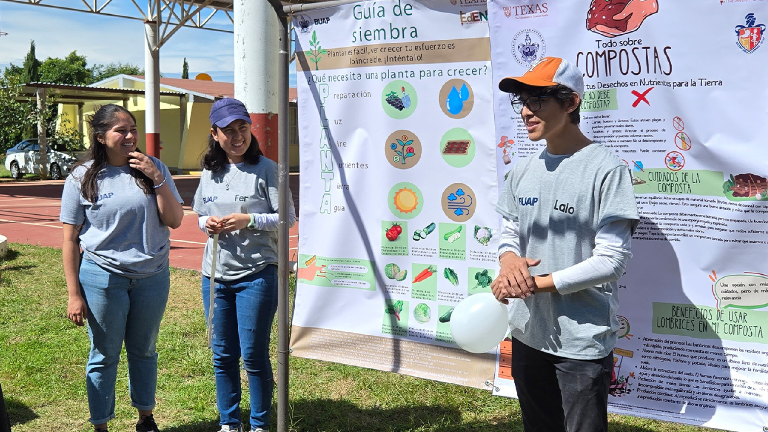 Three individuals stand in front of research posters on the topic of gardening.